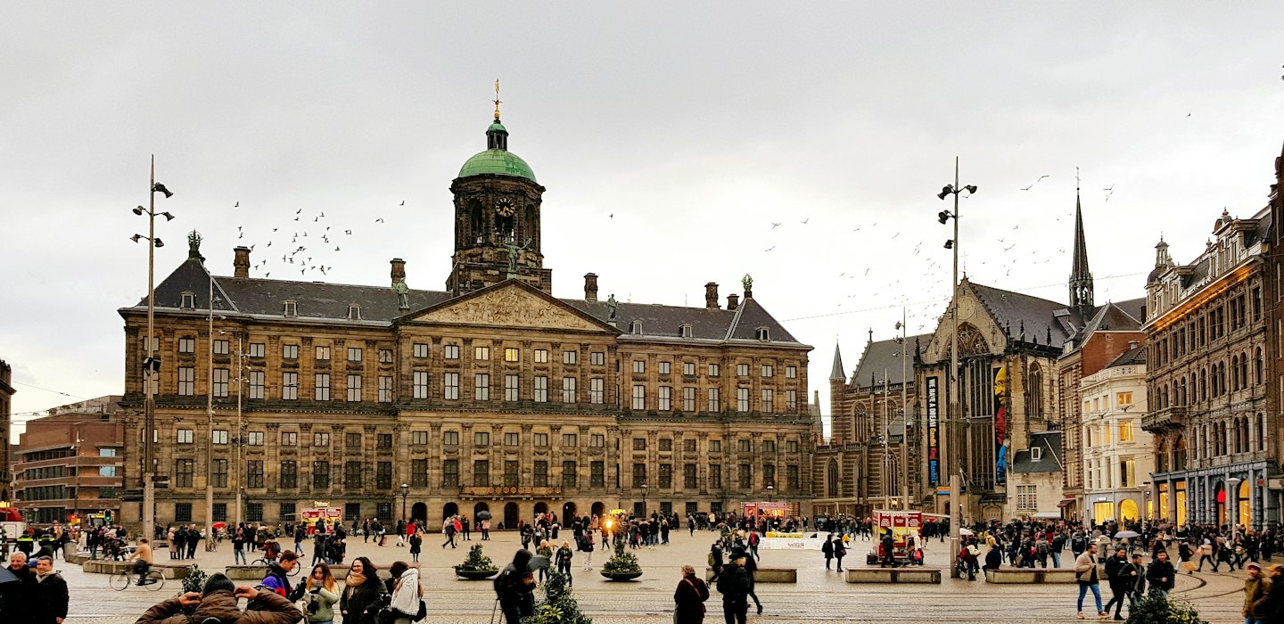 Mensenmassa loopt over het stadsplein voor het paleis.