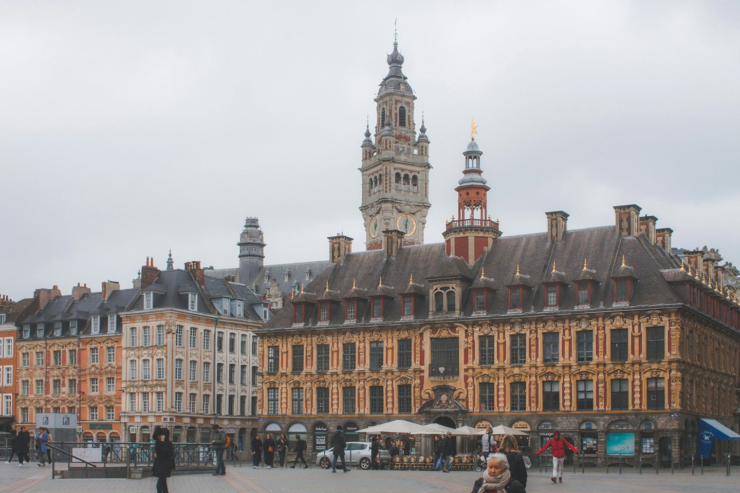 Voetgangers lopen over een geplaveid plein met historische gebouwen.